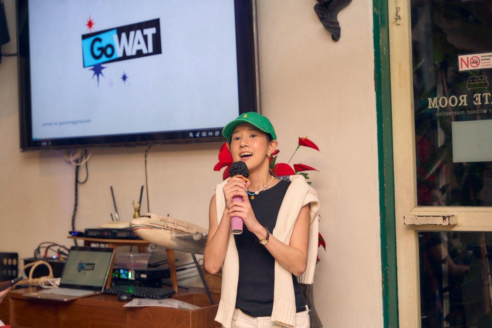 รุ่นพี่พูดบนเวทีด้วยไมโครโฟน หน้าจอฉายโลโก้ GoWAT